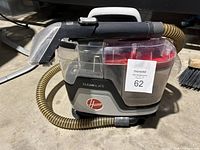 Side view of the Hoover Cleanslate carpet cleaner showing the main unit with handle, hose, and cleaning wand attached.