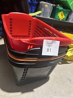 Stacked plastic tote bins including red, black, and orange, dusty and used.