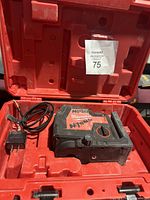 Laser level and USB charger cable inside red carrying case