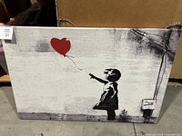 Front view of canvas showing artwork of a girl reaching towards a red heart-shaped balloon.
