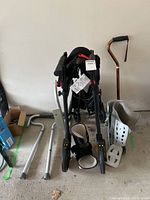 Nexus folding walker with basket, cane, and leg braces arranged together