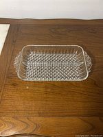 Angled side view of the glass tray highlighting the clear bubble texture and decorative handle on the opposite end.
