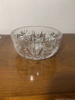 Side view of vintage heavy crystal bowl showing intricate pinwheel star cut pattern on the outside surface.