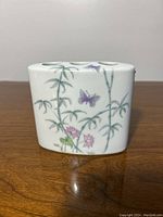 Porcelain toothbrush holder, front view showing floral and butterfly pattern with bamboo stalks