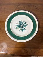 Full view of round turkey platter showing green border, white outer edge, and lily of the valley floral design in center