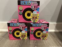 Front view of all 3 LOL Surprise Remix Hair Flip doll boxes stacked in a pyramid shape on the floor, showing packaging branding and artwork.