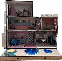 Front view of the entire wooden LOL dollhouse showing three floors, spiral staircase, pull-out drawer with pool and hot tub, and some furniture inside.