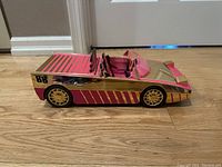Side view of the LOL Speedmatic car showing pink and gold color and racing stripes with number 88 decal