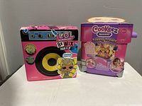 Front view of the boxed LOL Surprise Remix Hair Flip doll and Cookie Makery Toasty Treatz toy in sealed packaging.