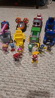 Entire Paw Patrol toy set laid on carpet including all vehicles and character figures.