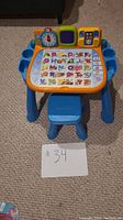 Full view of the blue VTech activity center desk with alphabet activity desktop and attached blue stool