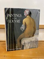 Front cover of the art book showing the title and artwork of a seated nude woman.