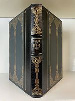 Front cover and spine showing black half-leather binding with gold gilt decorations and title 'Tales of Edgar Allan Poe'