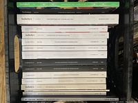 Photo showing stacked auction catalogues from Sotheby's, Christie's, and Bonham's with a variety of Post-War and Contemporary Art titles visible on the spines, from different years and cities.