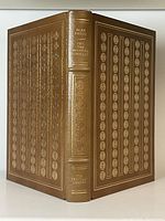 Full view of the book showing front, spine, and back covers with gilt leather binding and decoration.