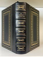 Front and spine view of the half-leather bound hardcover book with gilt lettering and gold embossed decoration on spine and covers.