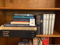 Books arranged on wooden bookshelf, showing various titles including Tesla, Reagan Diaries, Readers Digest series, and other historical/science books.