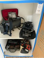 Full view of all cameras, binoculars, and accessories arranged on shelving cubbies.