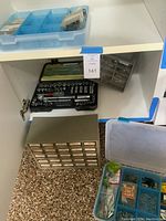 Shelf with socket wrench set, metal drawer organizer with labeled small hardware drawers, and plastic compartment organizer above