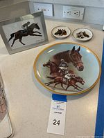 Full set view with the framed horse picture, two smaller round Kaiser Germany horse plates, and the large American Artists collector's plate on countertop.