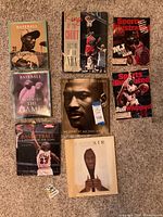 All seven books and magazines laid out on carpet showing cover art and titles related to Michael Jordan and baseball history.