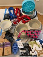 Overview photo showing dog bowls, collars, leashes, dog bandana, chew toy, and waste bags.