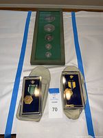 Top photo showing framed Philippine commemorative coin set and two U.S. military medals in plastic display cases