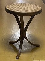 Front view of the bentwood side table showing round cane top and curved legs.