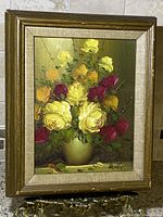 Front view of the framed vintage oil painting showing bouquet of yellow, orange, red flowers in vase signed Henry.