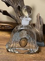 Full view of the clear crystal decanter with round stopper on top, showing overall shape and size.