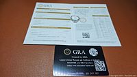 Ring displayed on GRA certification document verifying moissanite authenticity and details.