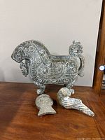 Three-quarter frontal view showing vessel and both ornaments