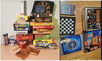 Close-up photo of board games piled and wooden game trays with dartboard behind