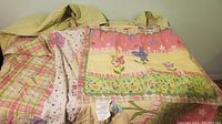 Photo showing colorful patchwork comforter with butterflies and floral accents