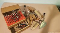 Overview of leather marking tools, wooden box with drawer, shoe stretchers, and metal shoe stretching tools.