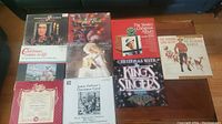 Top-down photo showing ten vinyl LP records with Christmas and holiday music themes, arranged on a wooden surface.