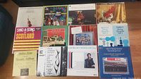 Photo showing 12 vinyl record albums with various colorful covers including classical, folk, and choral music.