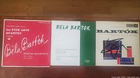 Photo of three vinyl record albums featuring Bela Bartok compositions, arranged side by side on a wooden floor.