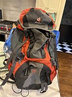 Photo of Deuter mountaineering hiking backpack showing front and side straps, orange and grey color scheme.