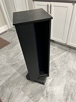 Photo of tall black wood grain finish CD stand holder with velvet inserts and a rotating base.