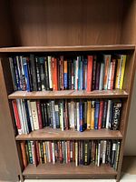 Full view of three shelves with various books on business, psychology, politics, history, and software.