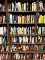 Front view of 6-shelf bookcase filled with assorted books of various subjects and conditions.