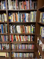 Upper four shelves containing assorted paperback and hardcover books on various topics