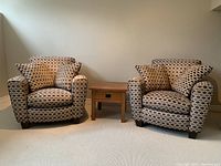 Both club chairs shown side by side with four toss pillows