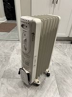 Front/right side view of Maxheat electric radiator heater showing control knobs and power indicator light.