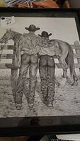 Front view of the framed and matted artwork showing the full drawing with cowboy and cowgirl and horse, artist signature visible.