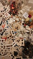 Large assortment of buttons on cards and loose within the tin