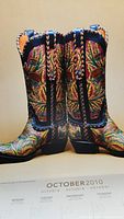 Close-up image of cowboy boots with elaborate floral embroidery in greens, yellows, and reds, displayed on the October 2010 calendar page