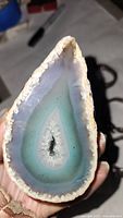Photo of the half cut geode showing interior layers with shades of white, blue and turquoise.