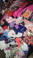 Overview of assorted scarves and handkerchiefs in various fabrics and colors including bright floral and solid patterns.